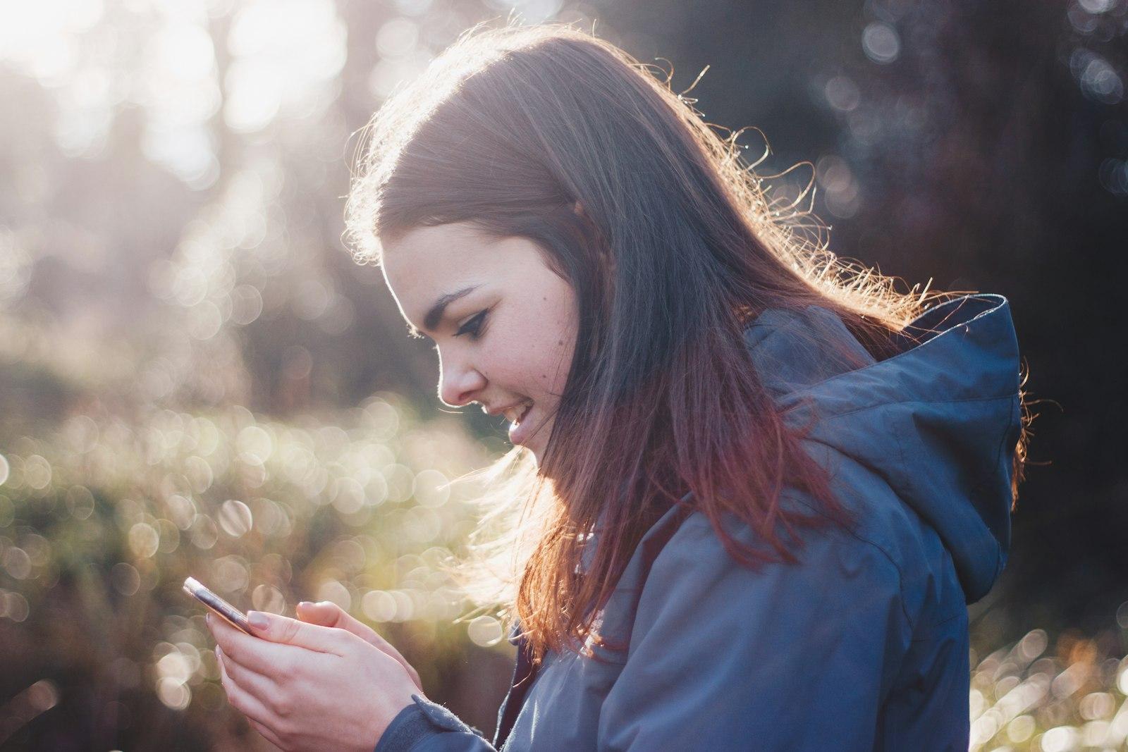 Cliente sorrindo ao receber atendimento rápido pelo celular